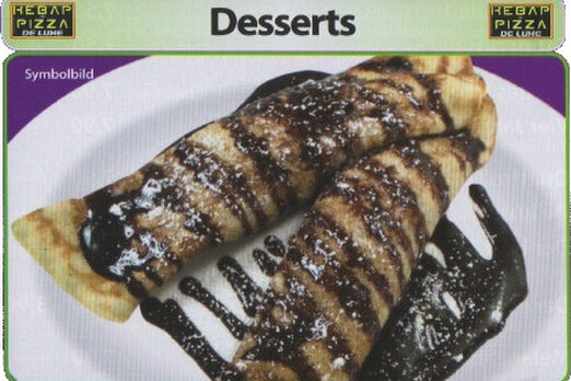 Frisch zubereitete, dünne Palatschinken, goldbraun gebacken und mit Schokolade gefüllt, dekoriert als süßes Dessert.